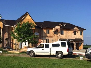 Pre-construction home with construction crew installing custom windows & doors in Mississauga.